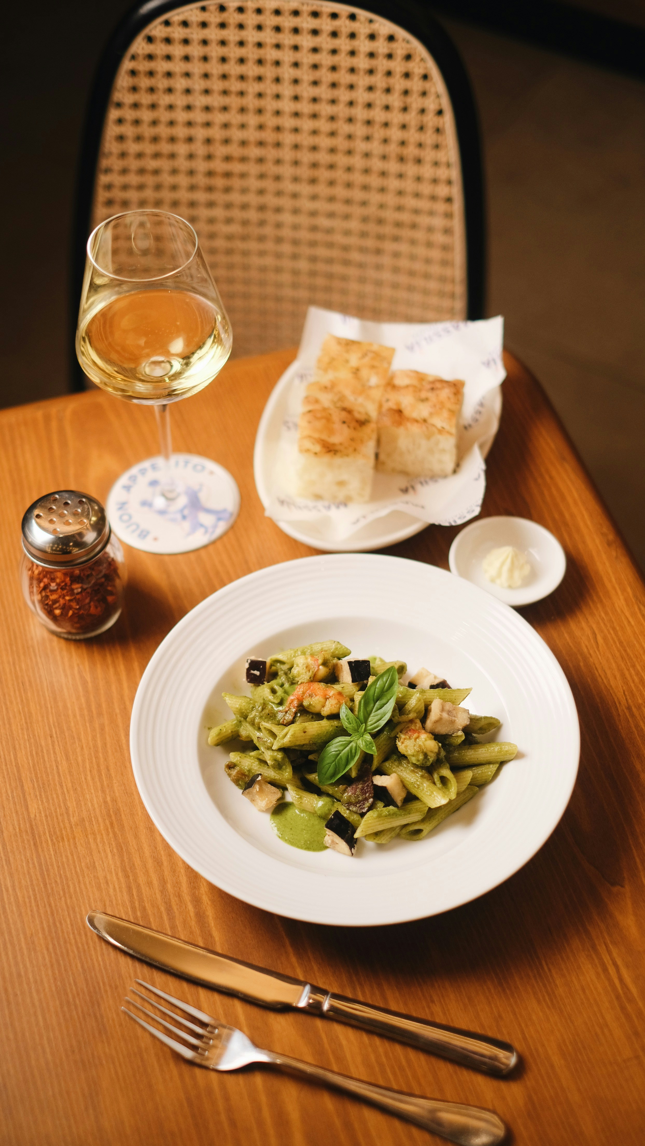 A table with a plate of food and a glass of wine