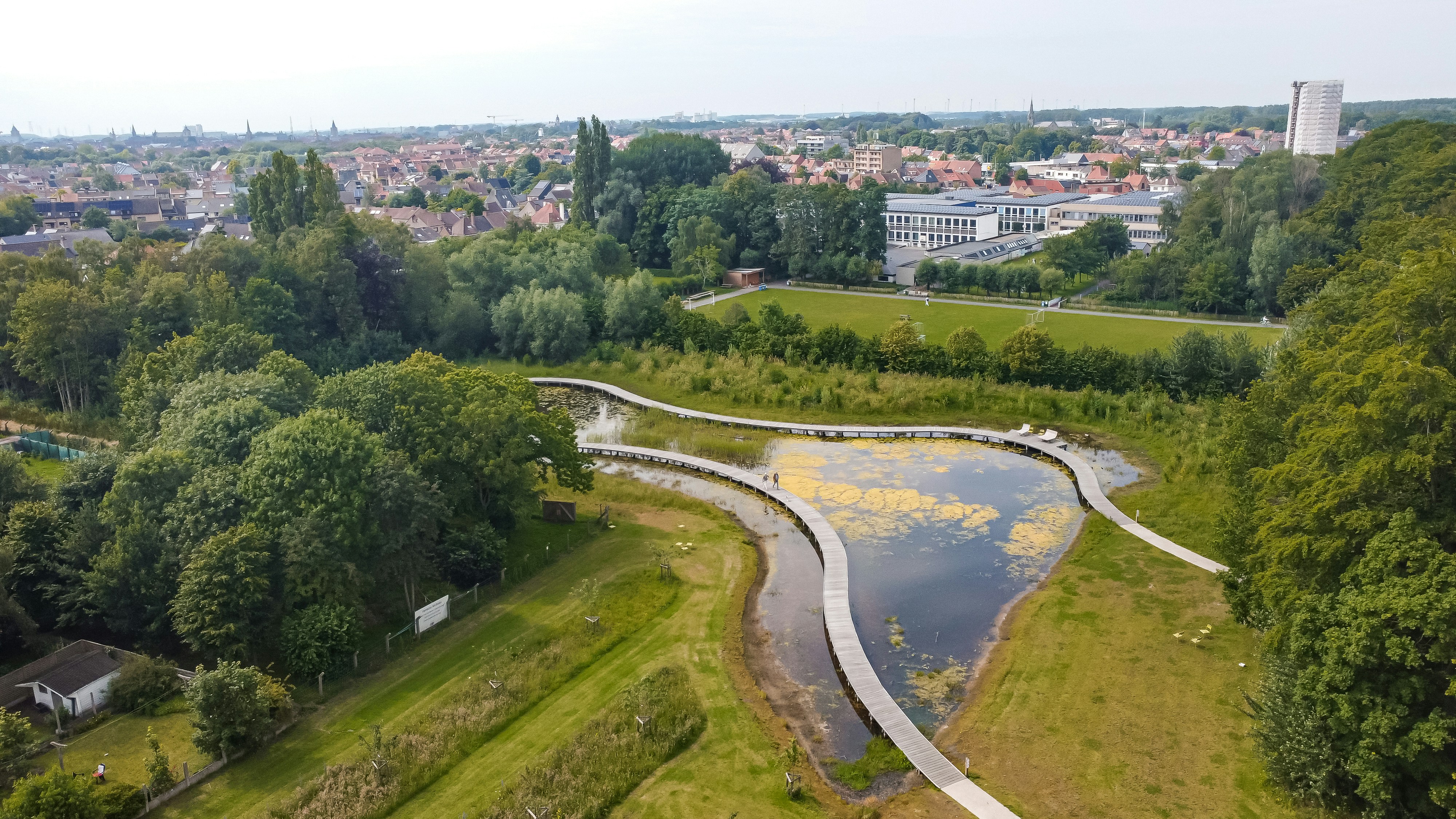 A bird's eye view of a park with a river running through it