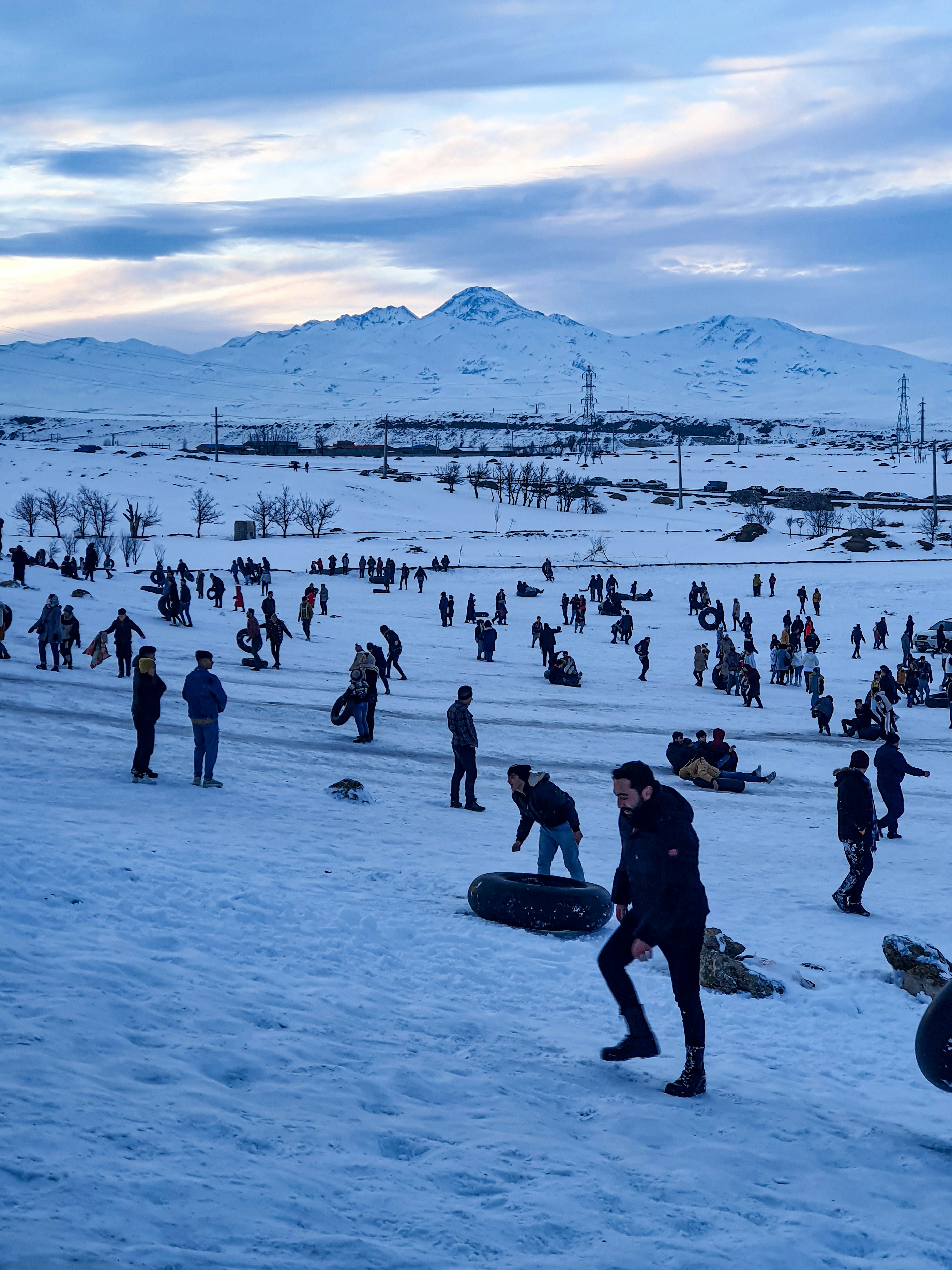 A crowd of people walking across a snow covered field
