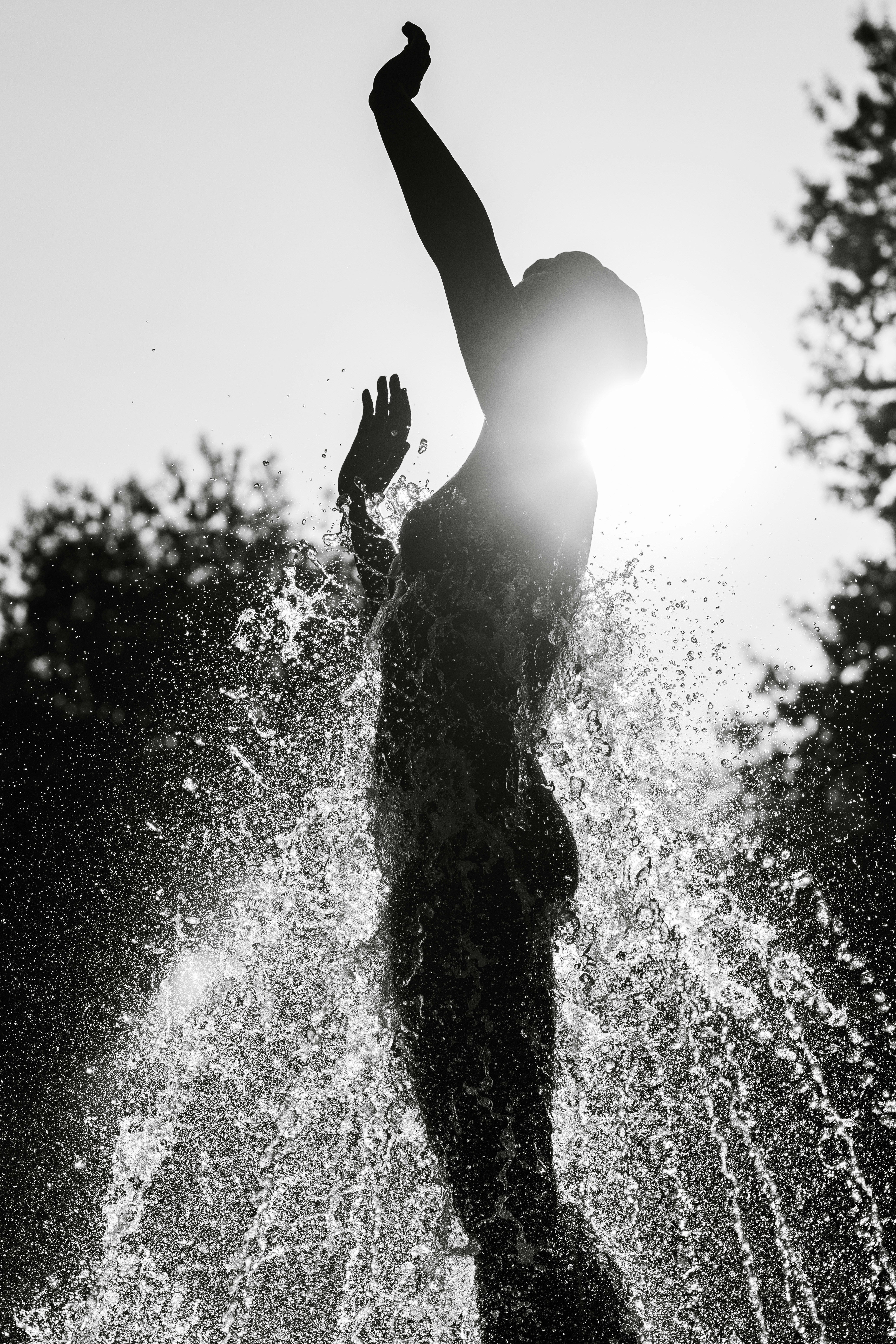 A person standing in the water with their arms in the air