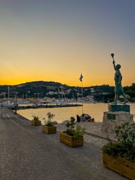 A statue of a woman holding a torch near a body of water