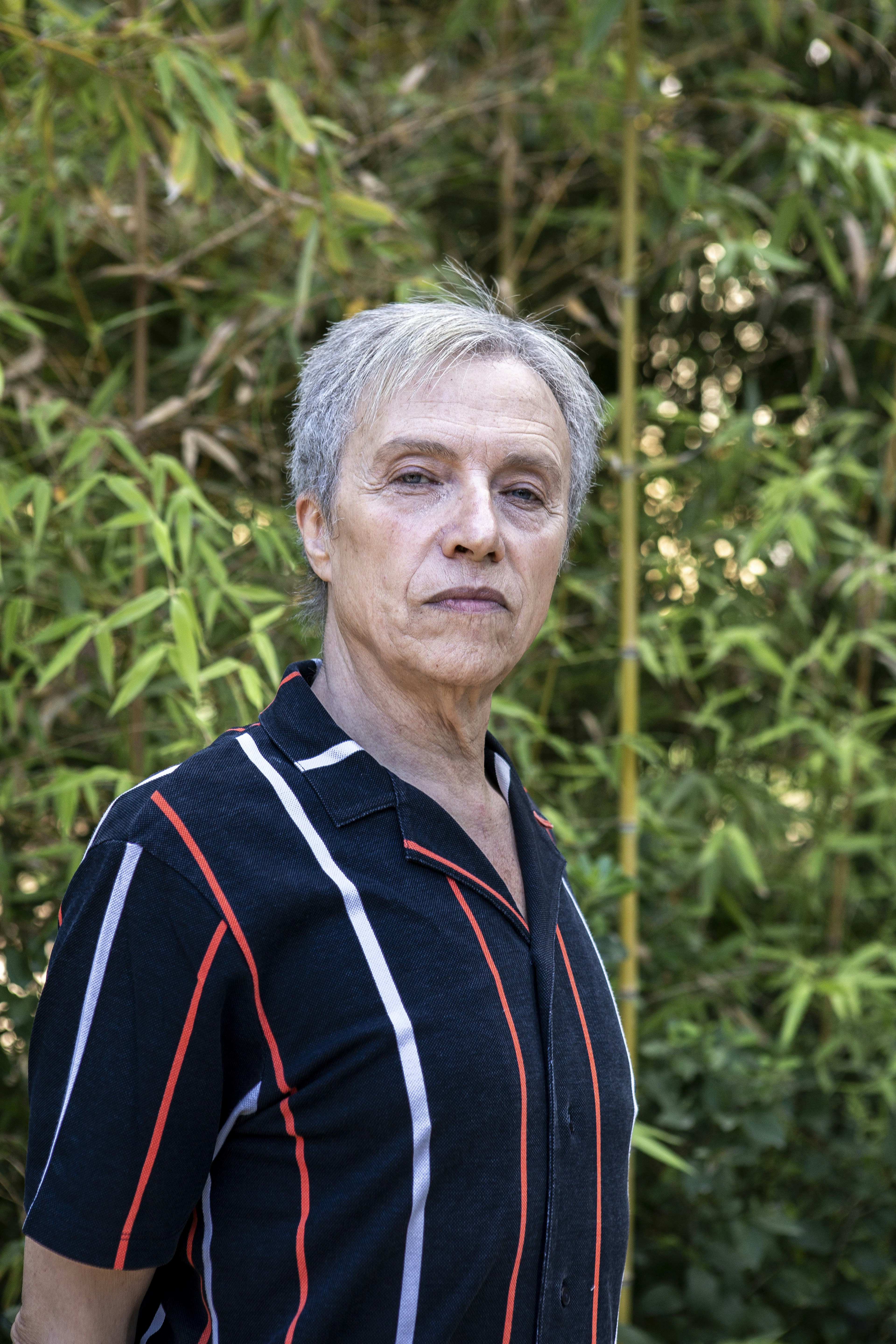 A man standing in front of a bamboo tree