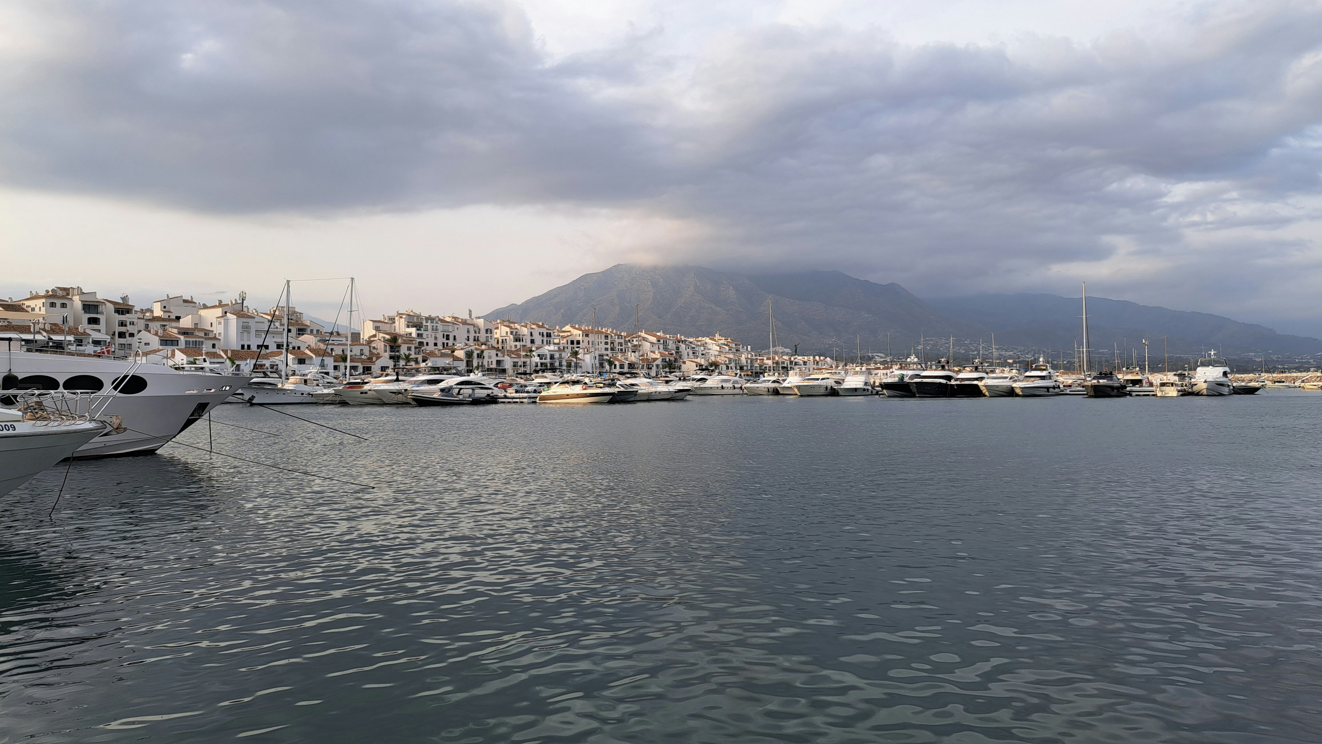 A harbor filled with lots of boats under a cloudy sky