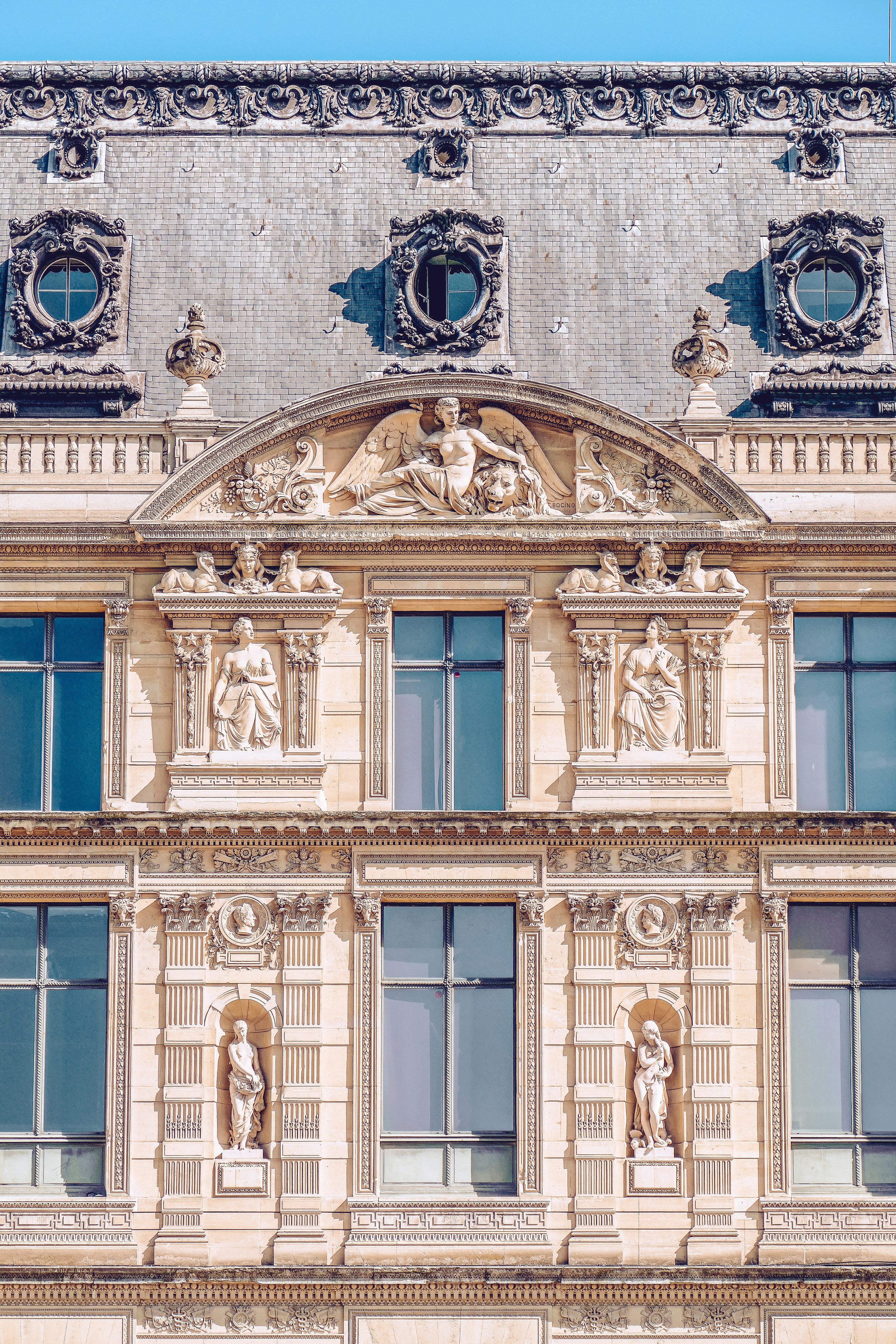 Ein großes Gebäude mit vielen Fenstern und Statuen darauf