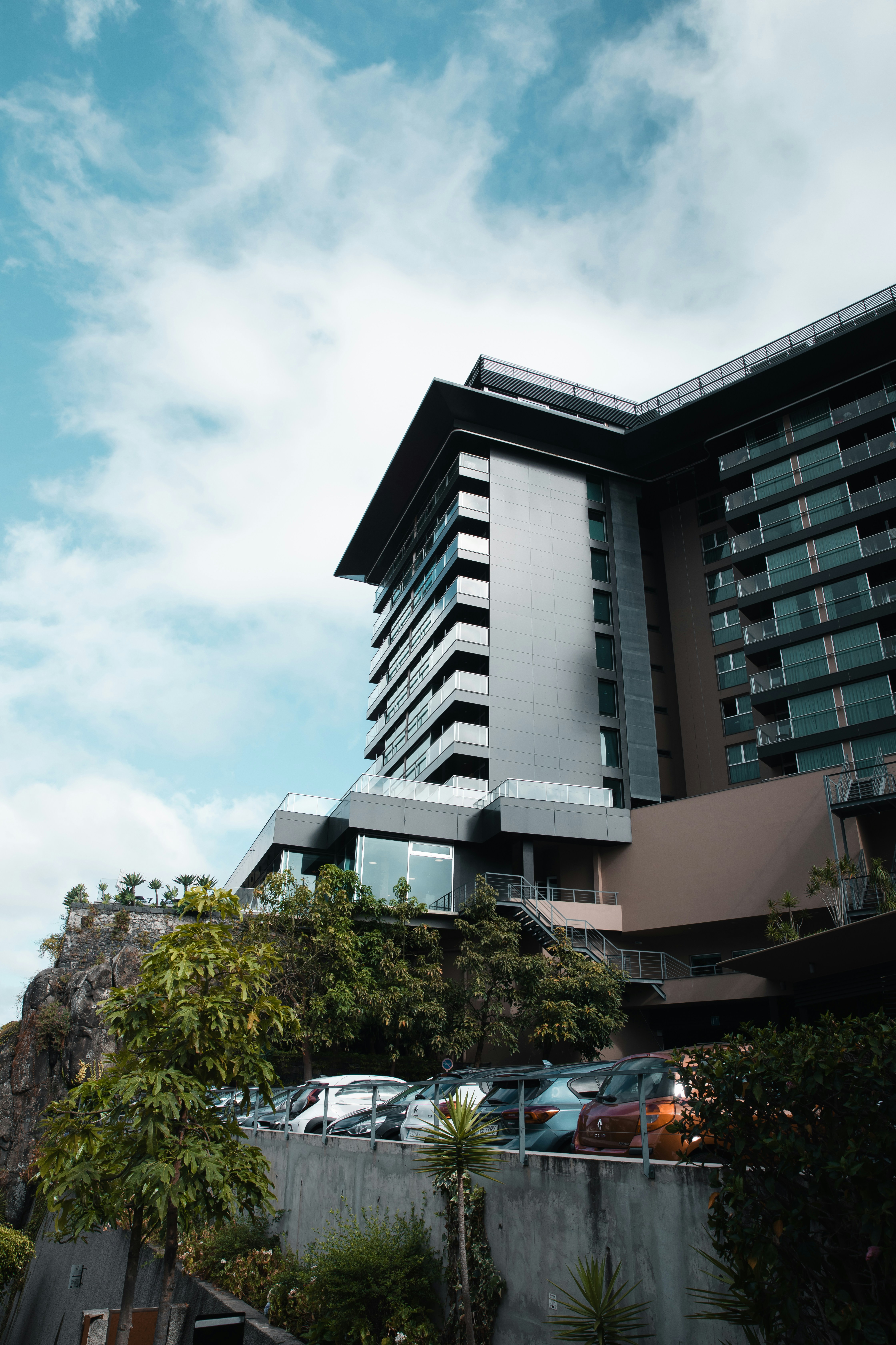A very tall building with cars parked in front of it