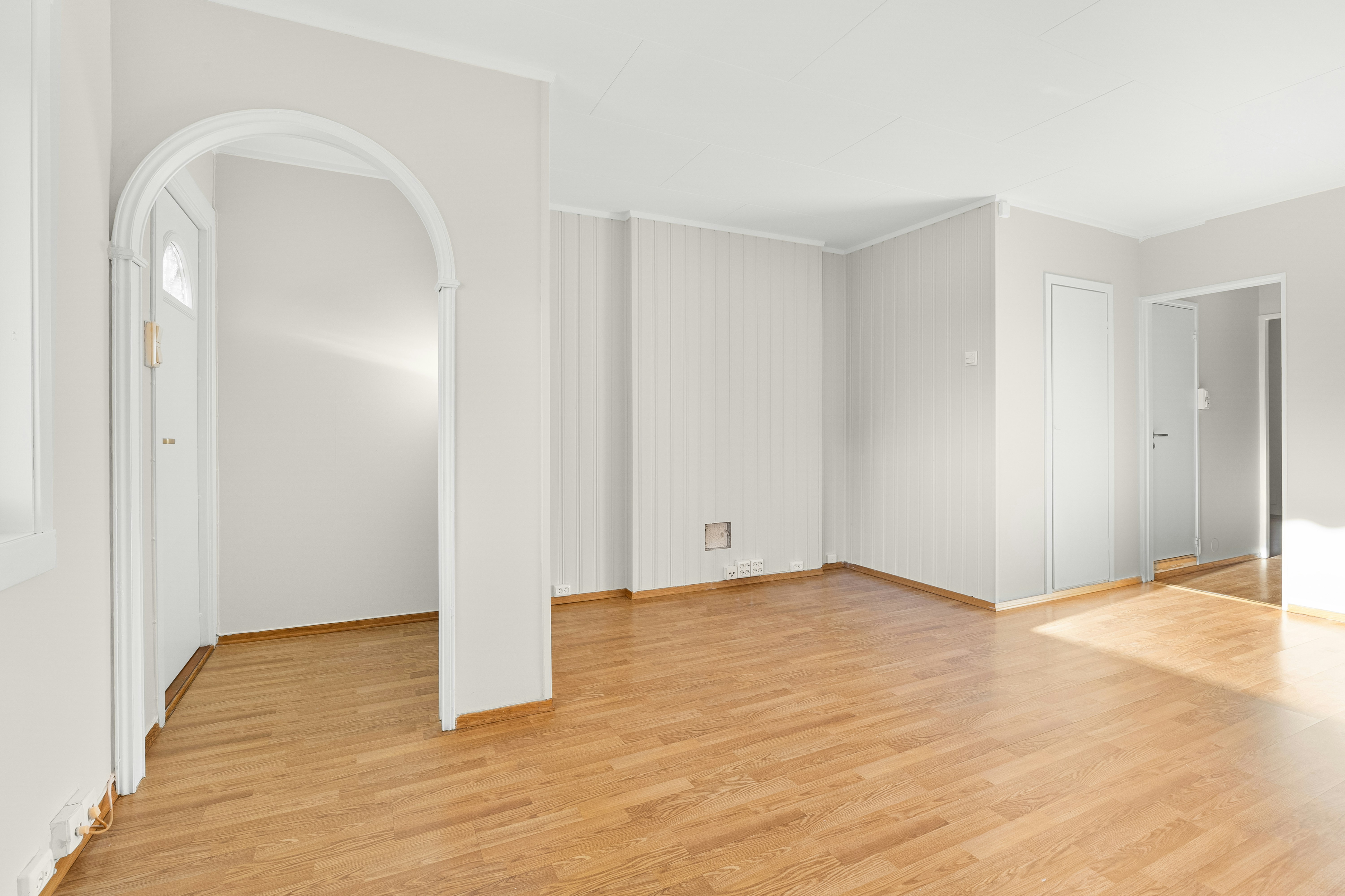 An empty room with white walls and wood floors
