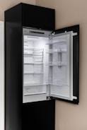 A black refrigerator with its door open in a kitchen