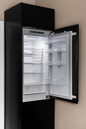 A black refrigerator with its door open in a kitchen