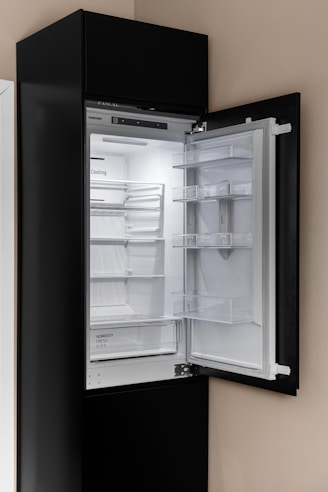A black refrigerator with its door open in a kitchen