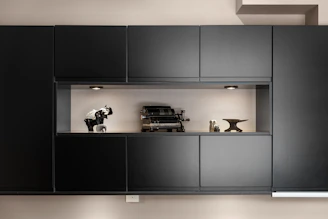 A kitchen with black cabinets and white walls
