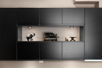 A kitchen with black cabinets and white walls