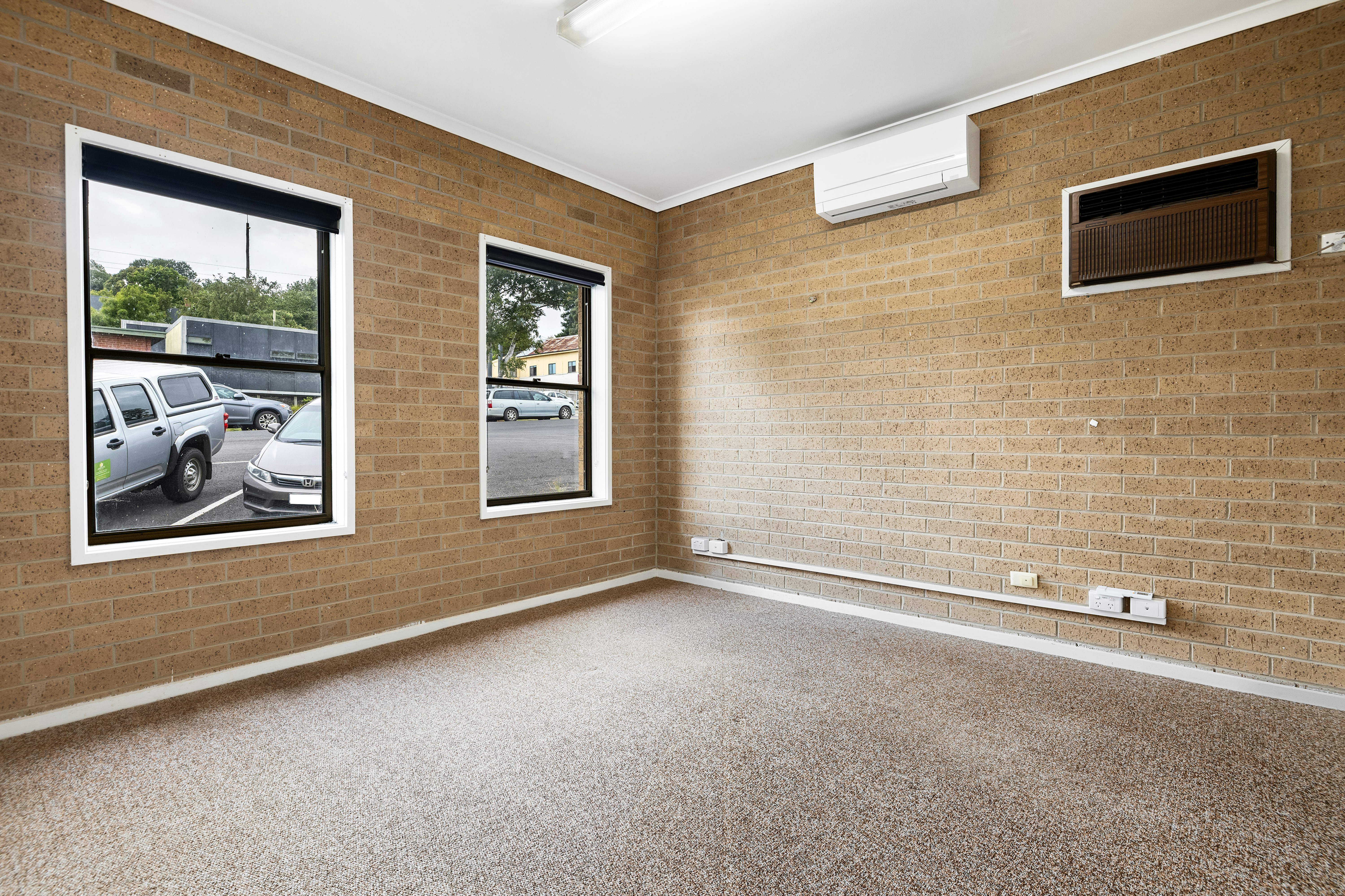 Empty room with brick wall and split-system air conditioner