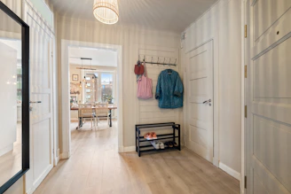 A hallway with a coat rack and a bench