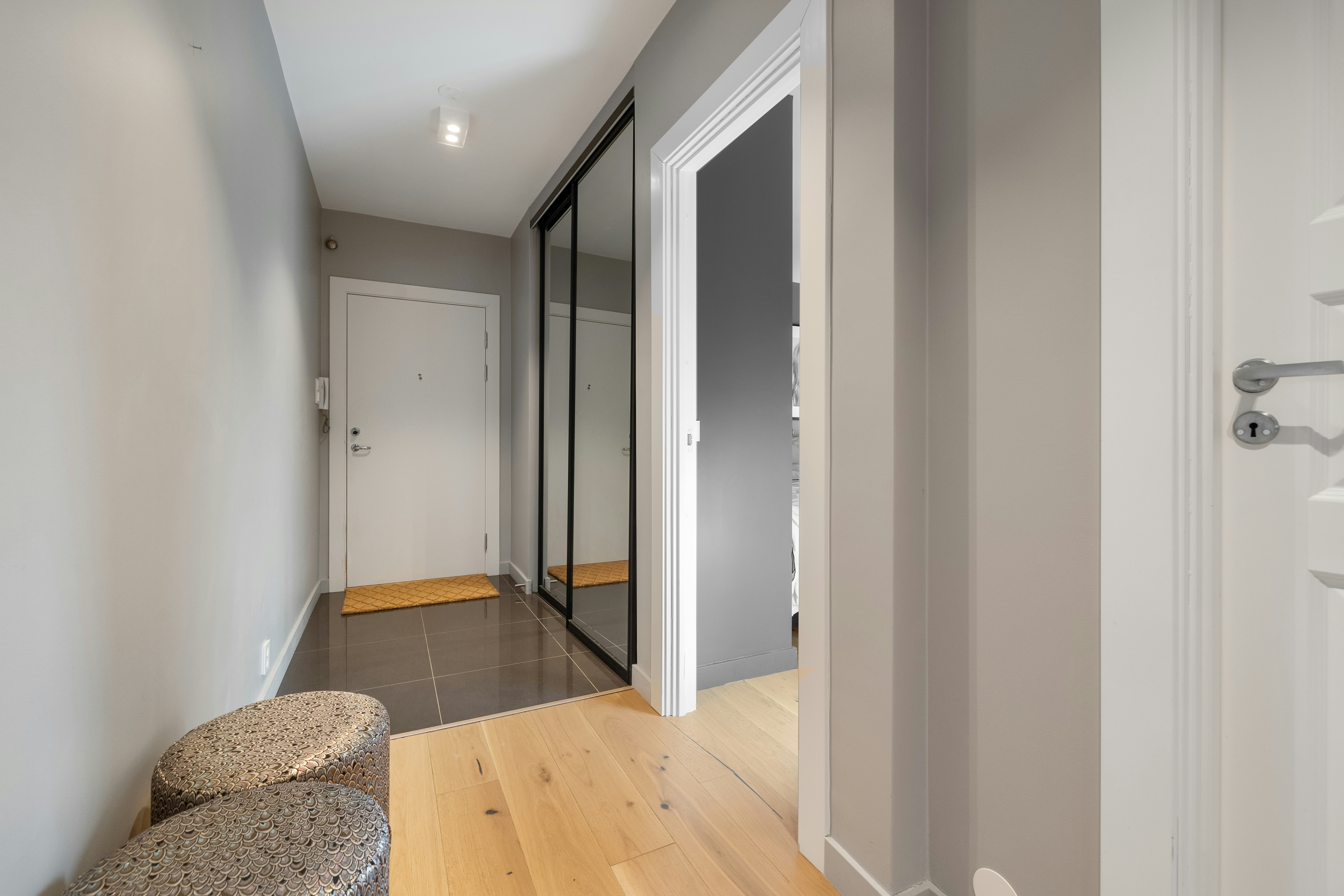 A hallway with a chair and a door