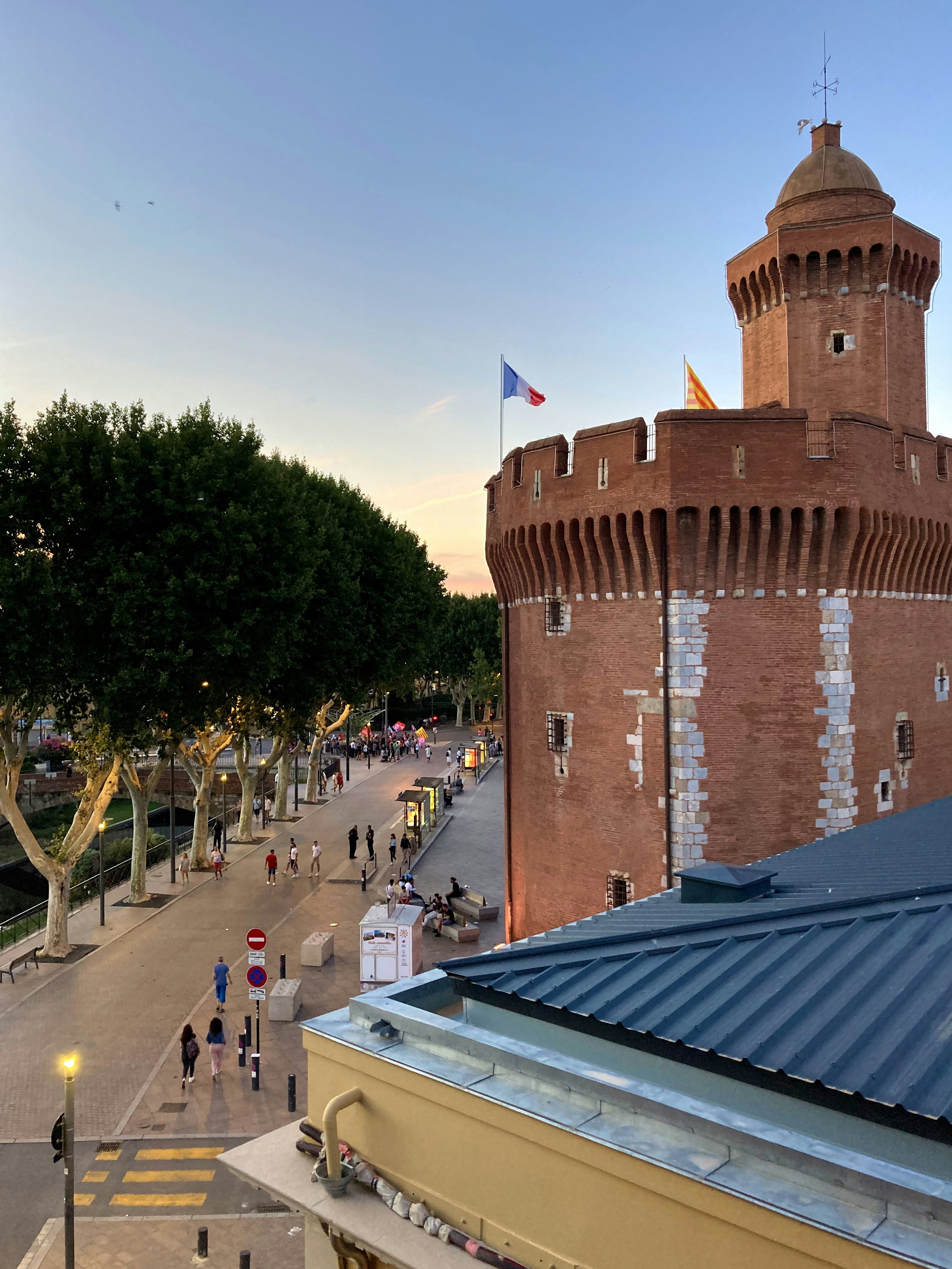 A tall brick building with a blue roof