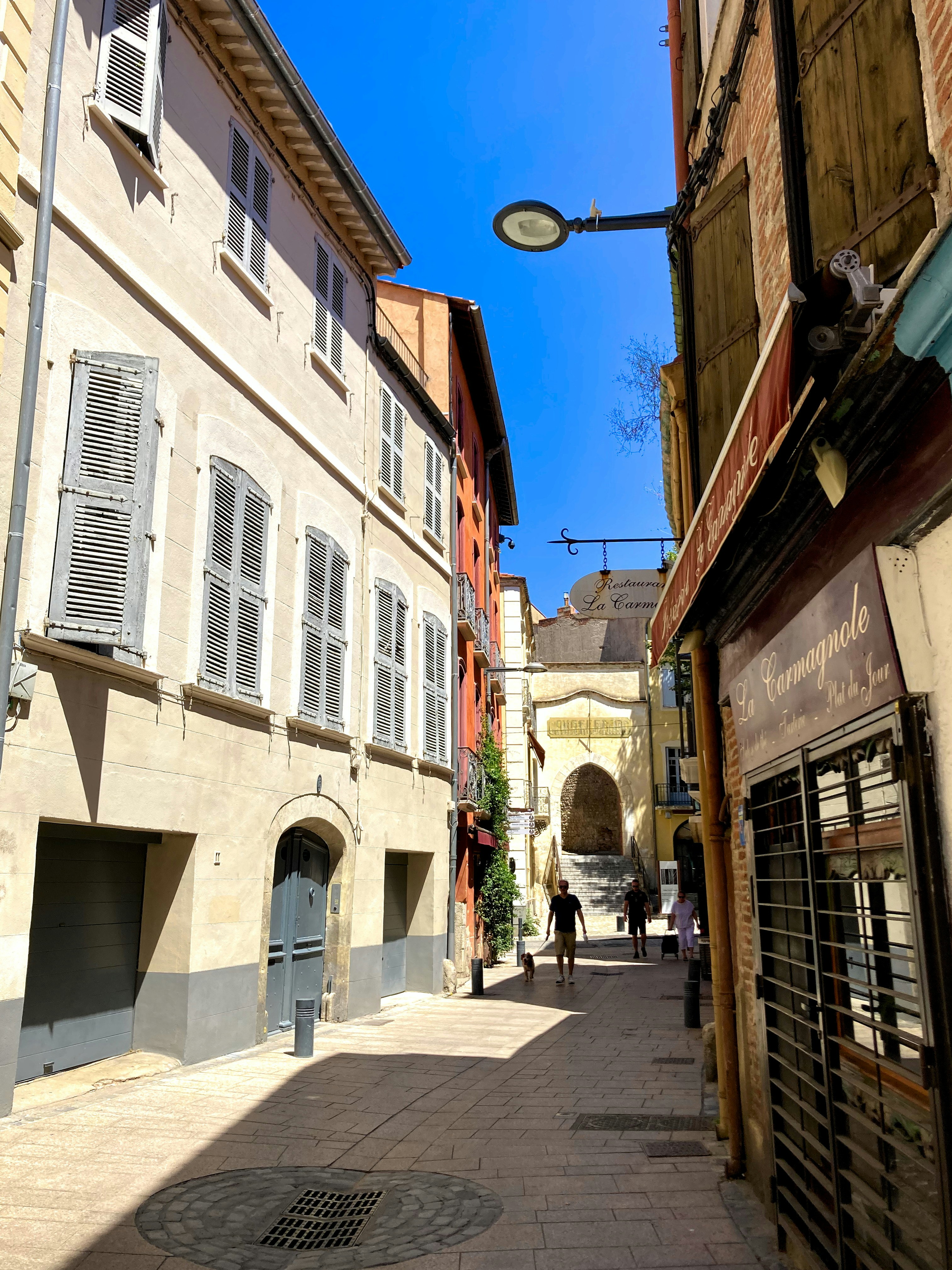 A narrow street with buildings and a street light