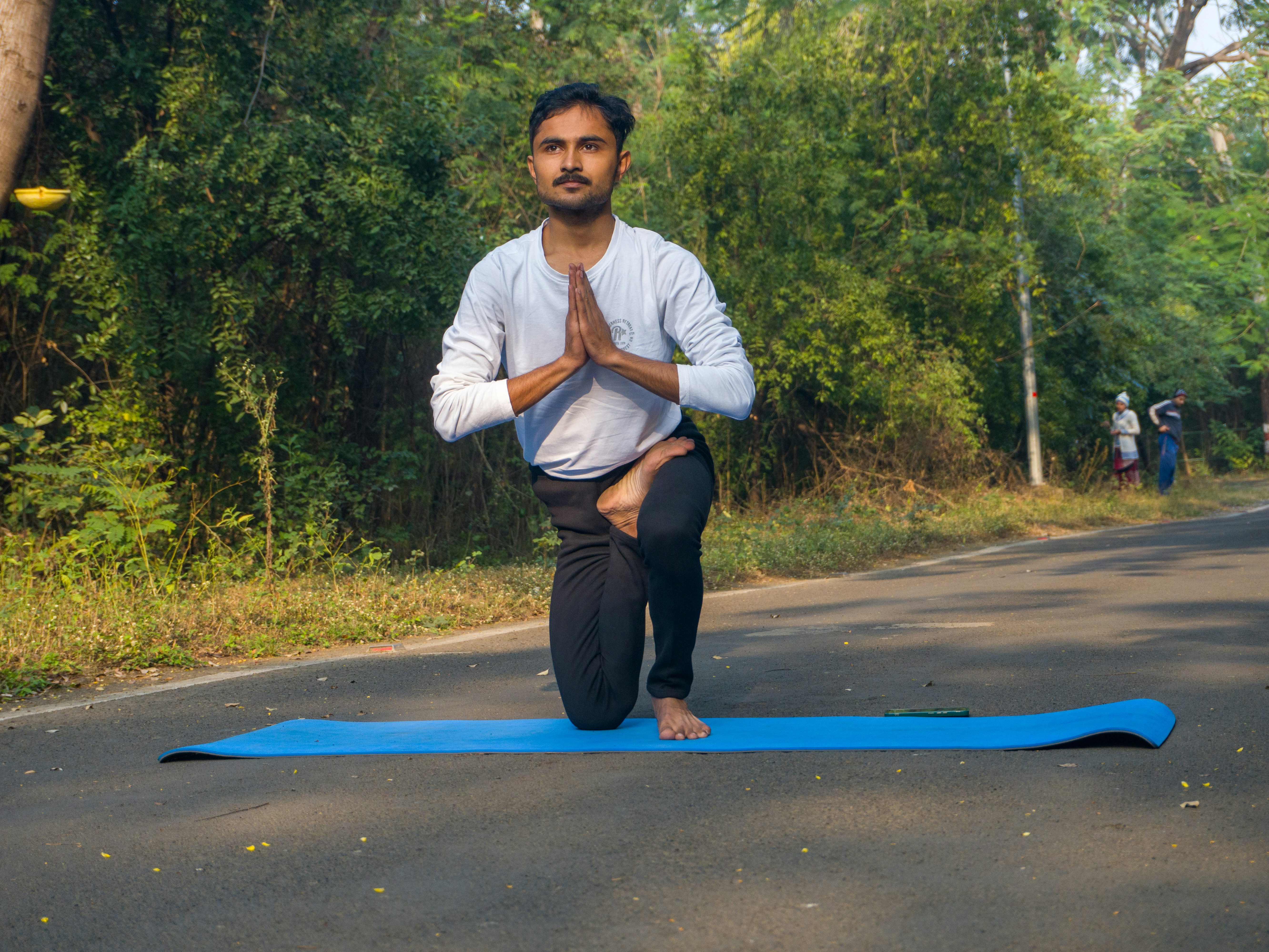 A man is doing yoga on a blue mat