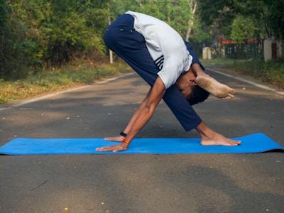 A man doing a yoga pose on a blue mat