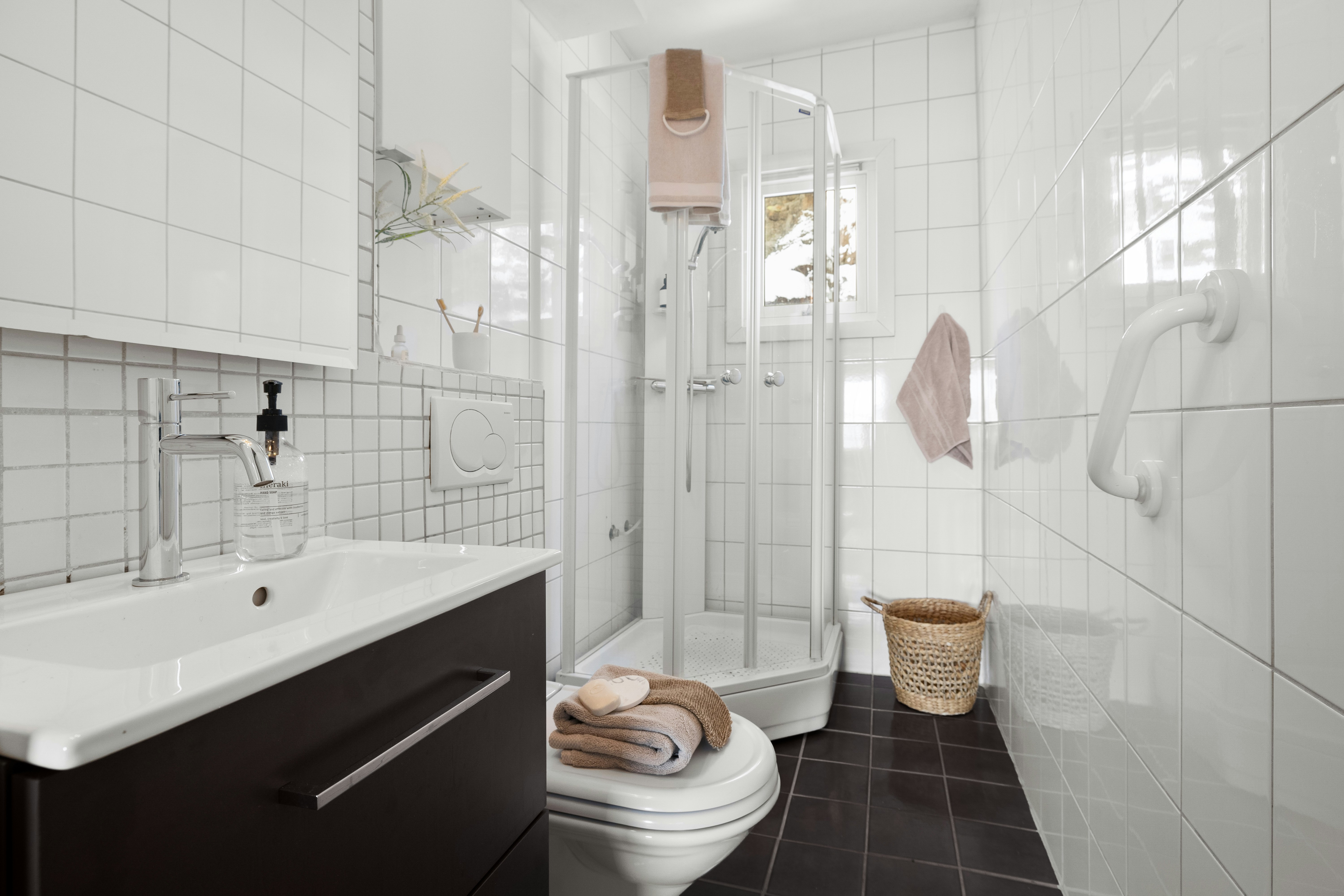 A bathroom with a toilet, sink, and shower