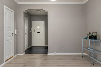 An empty room with a shelf and a door