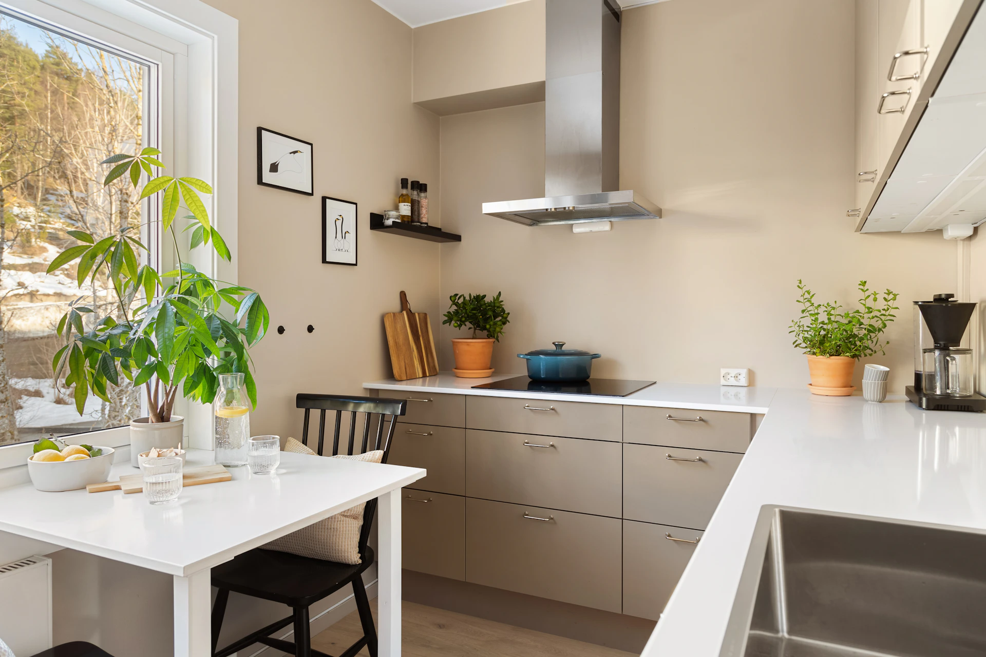 A kitchen with a white table and chairs