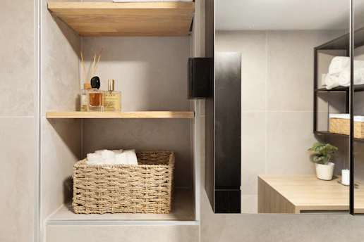 A bathroom with a sink, mirror and shelves
