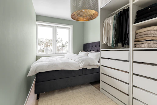 A bedroom with a bed and a closet
