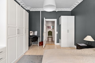 A room with a bed, a desk, and a closet