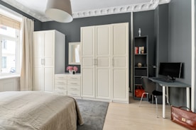 A bedroom with a large bed and a desk