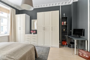 A bedroom with a large bed and a desk