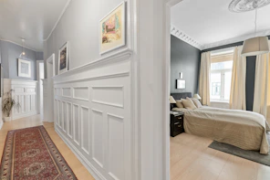 A hallway with a rug and pictures on the wall