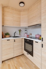 A kitchen with wooden cabinets and a black stove top oven
