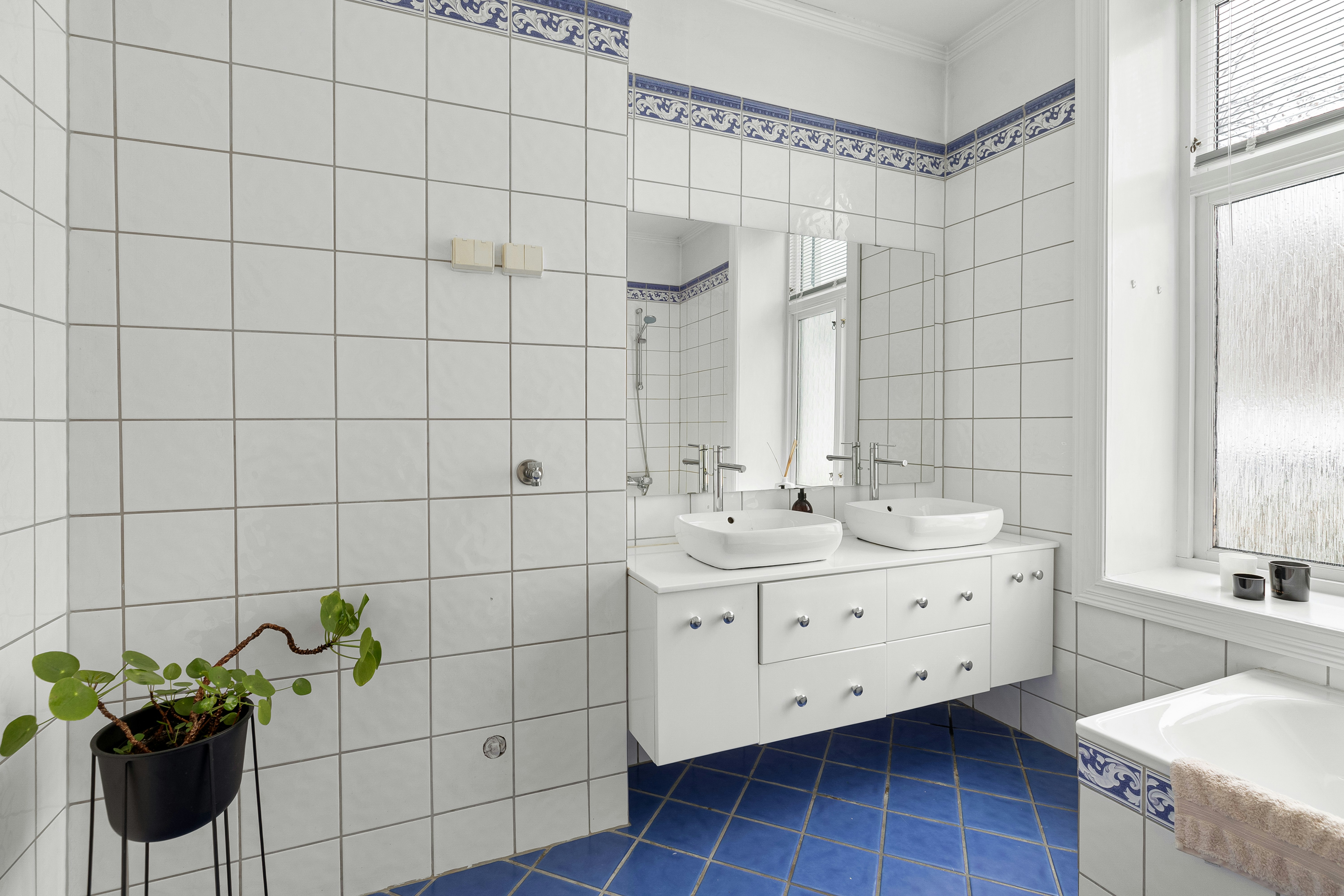 A bathroom with a blue floor and white walls