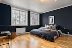 A bedroom with blue walls and wood floors