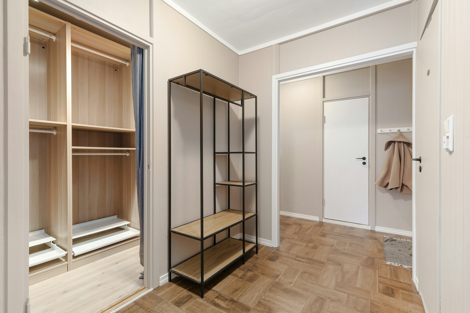 A walk in closet next to a closet door