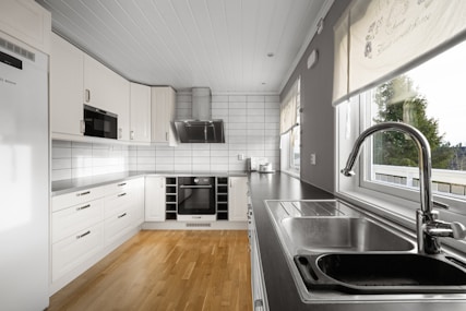 A kitchen with a sink and a refrigerator
