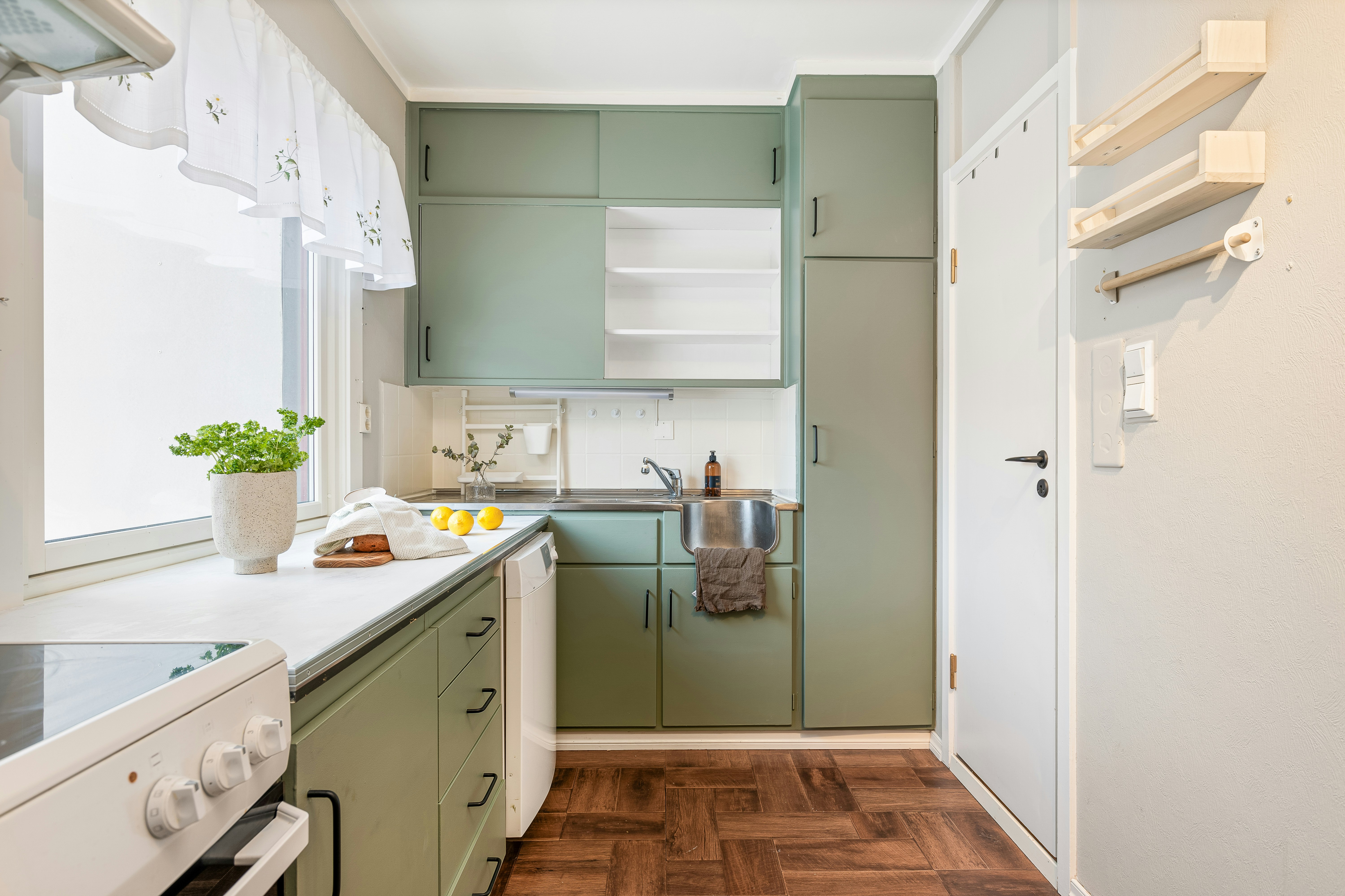 a kitchen with light green cabinets and layered lighting - country small kitchen ideas