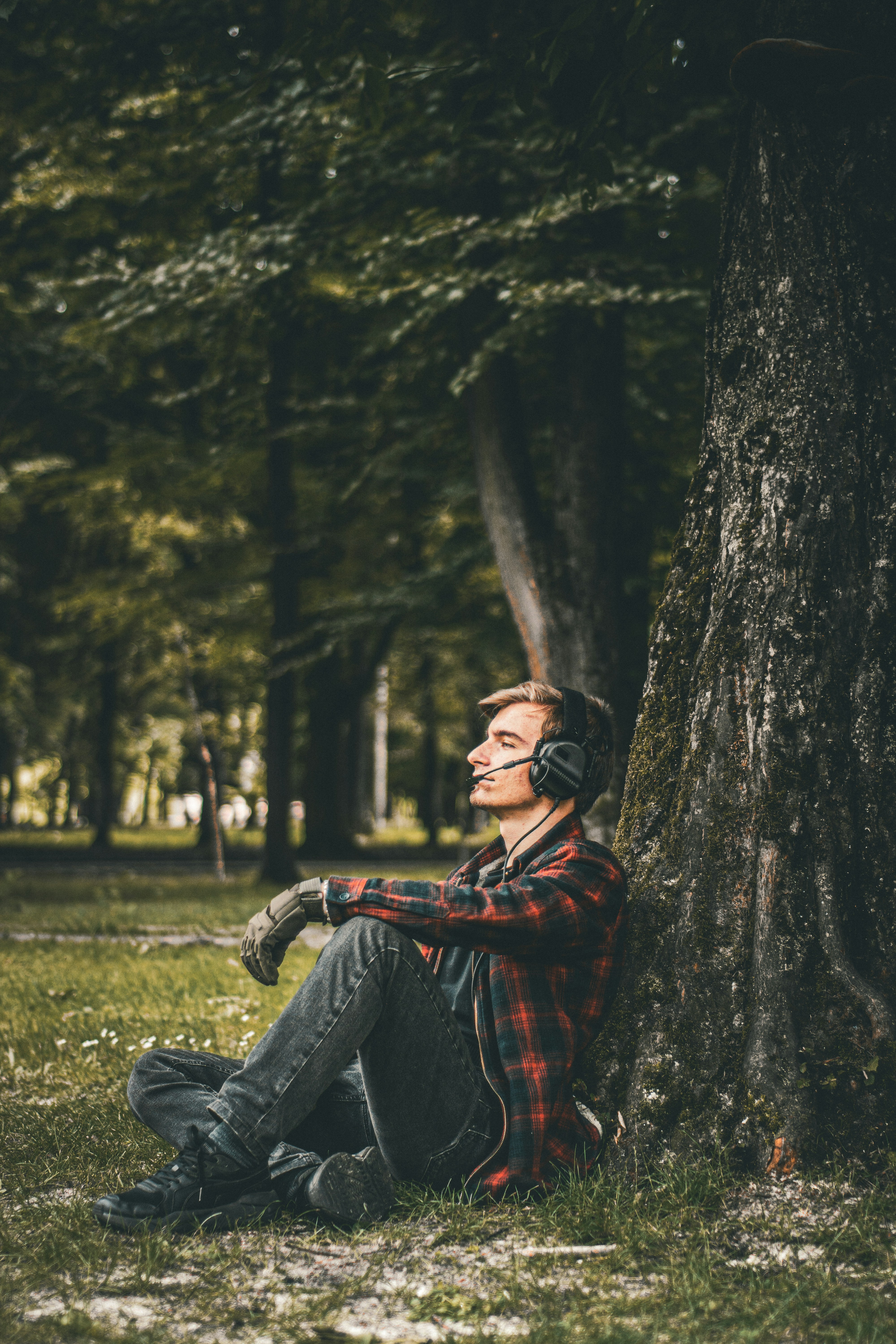 A man sitting in the grass next to a tree