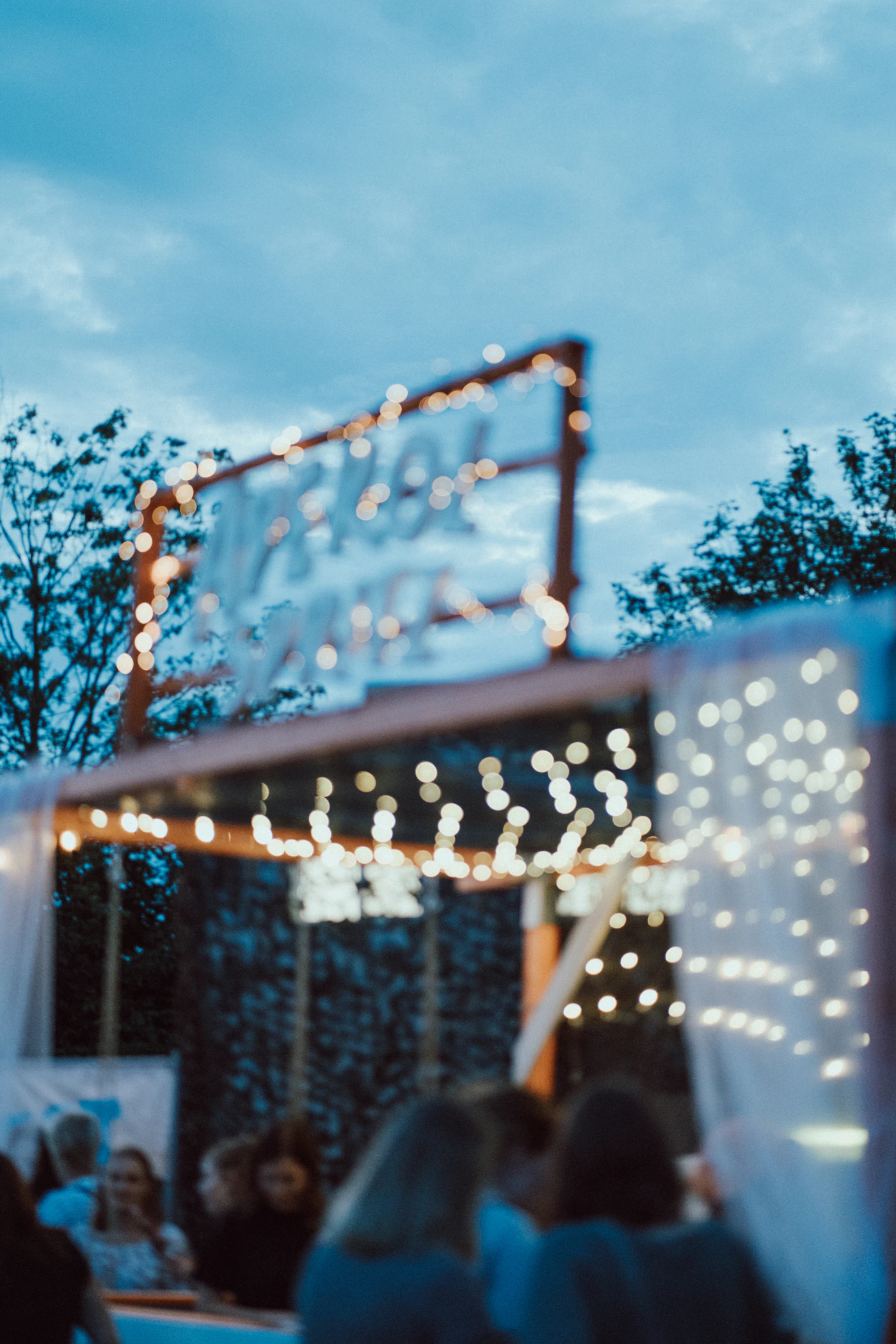 A long candlelit dinner table set under warm light