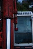 A close up of a red fire hydrant with a bus in the background