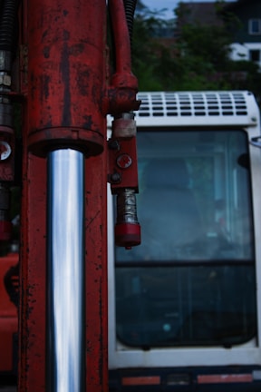 A close up of a red fire hydrant with a bus in the background