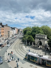 A train traveling down a street next to tall buildings