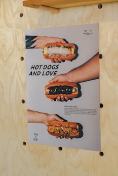 A poster of hot dogs and love hanging on a wall