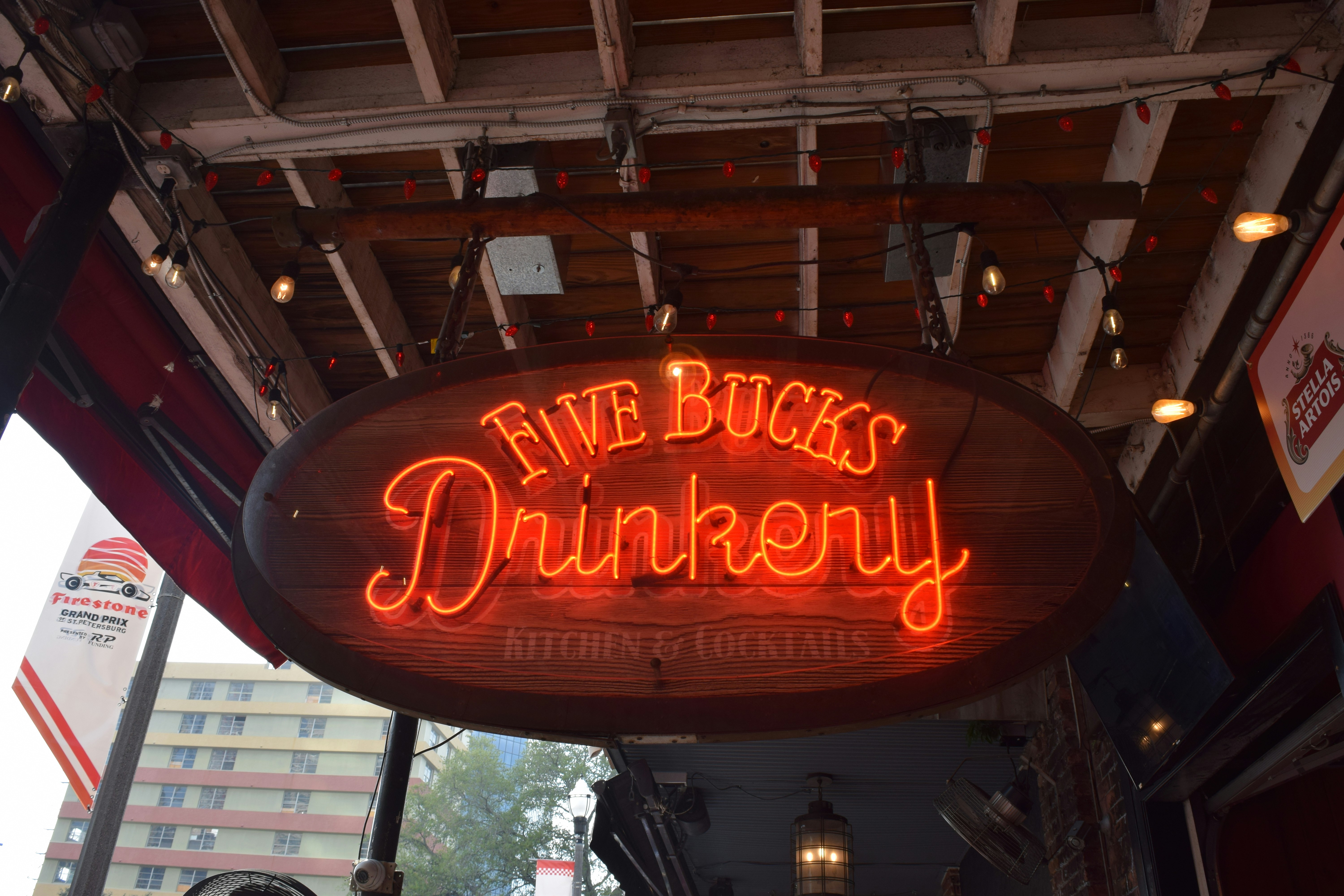 A neon sign hanging from the side of a building