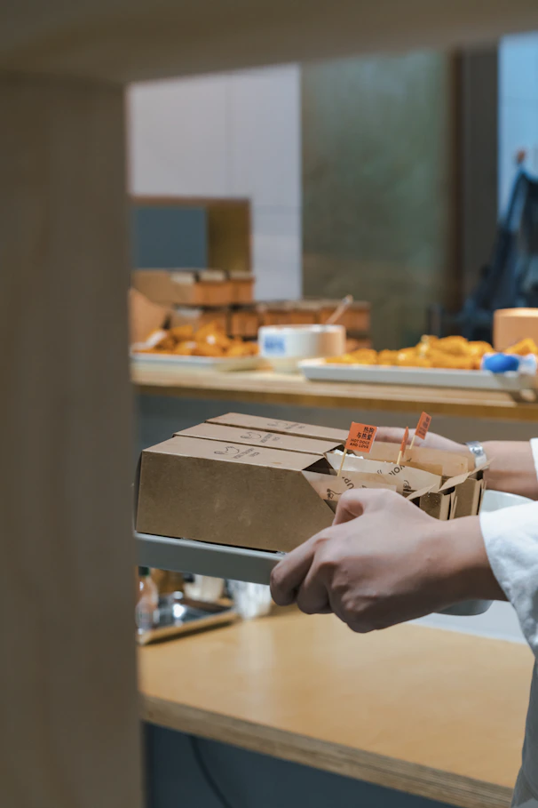 A man in a white shirt is holding a box