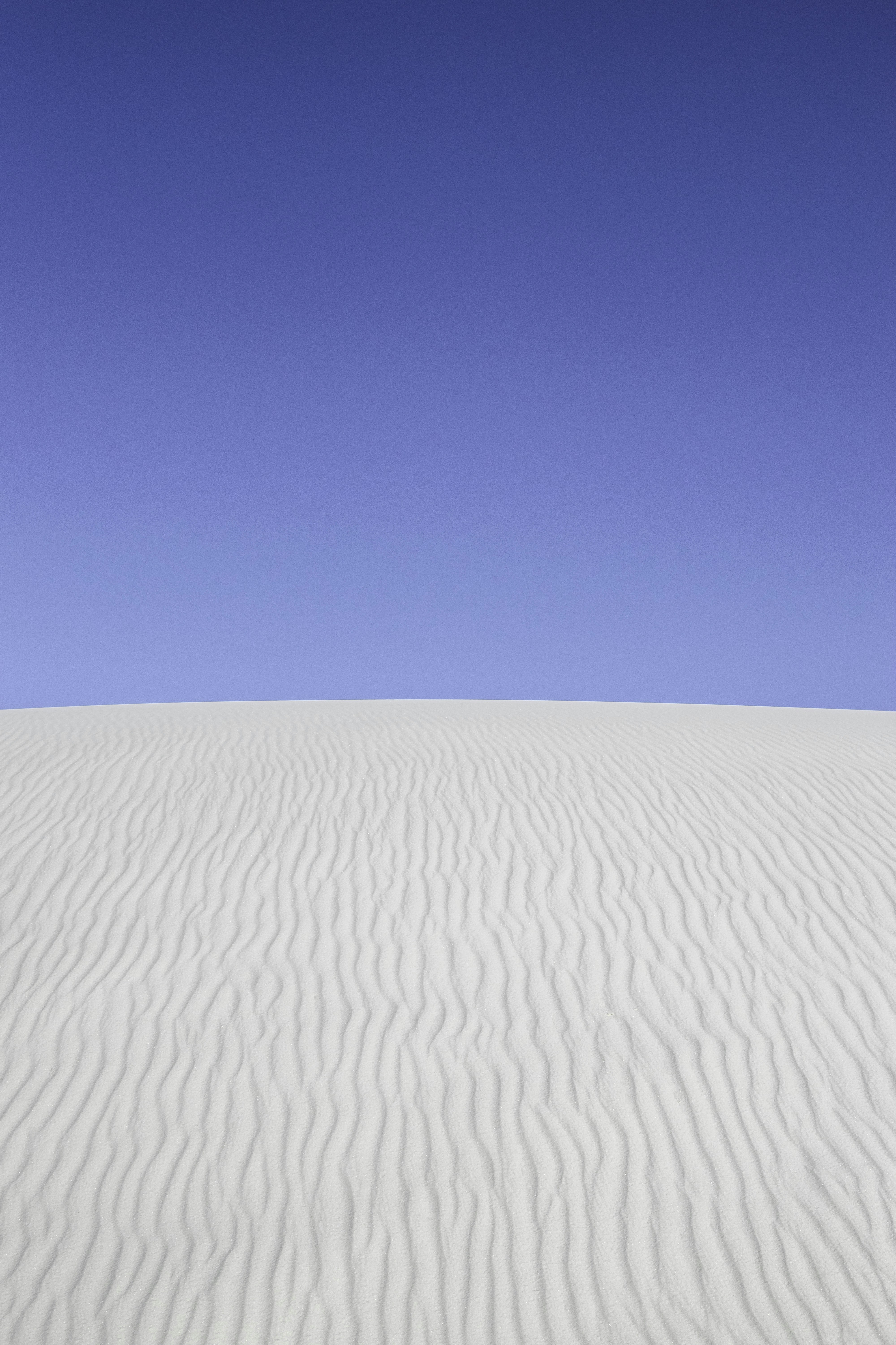 A white sand dune under a blue sky