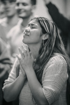 A woman is praying in a crowd of people