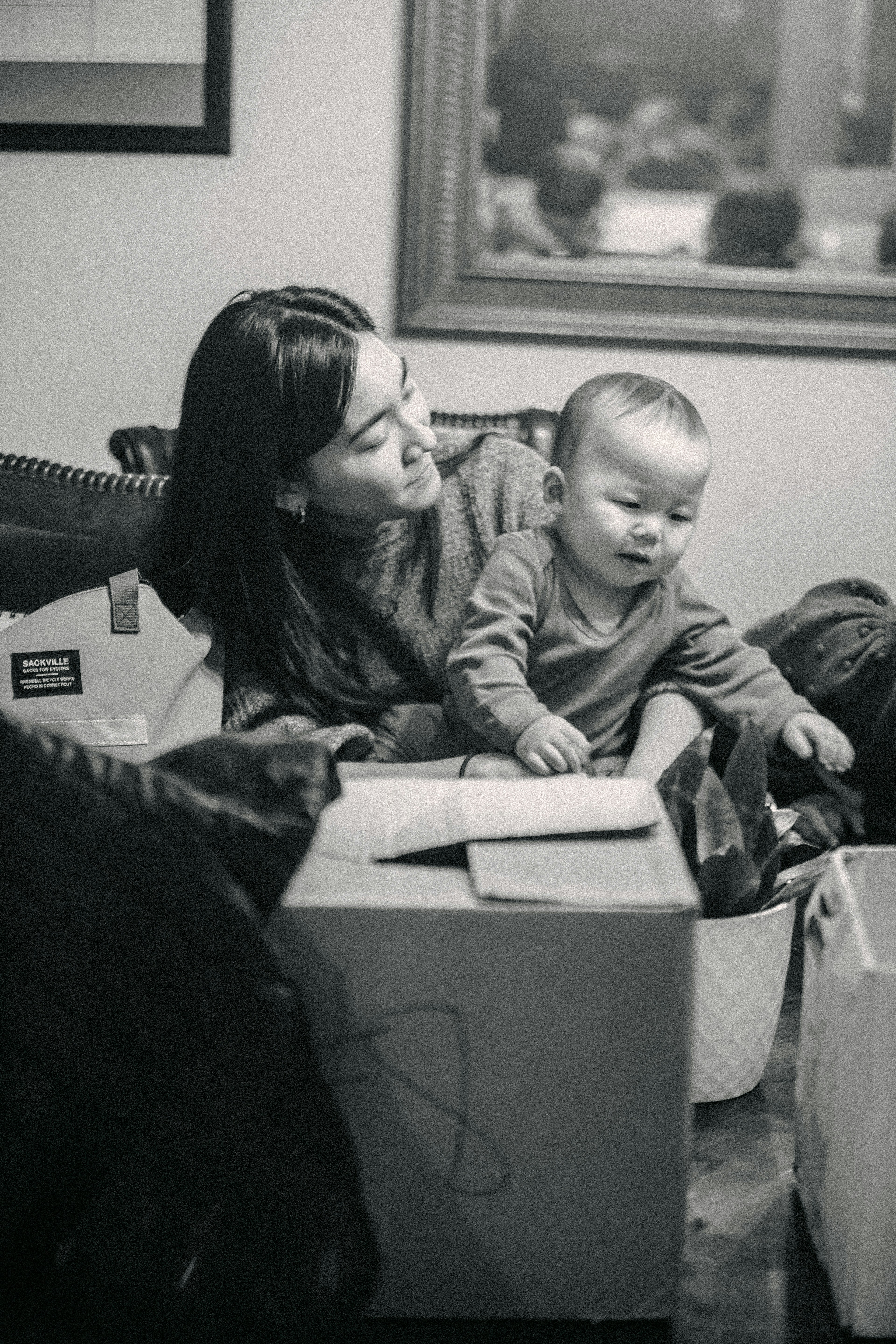 A black and white photo of a woman and a baby in a box