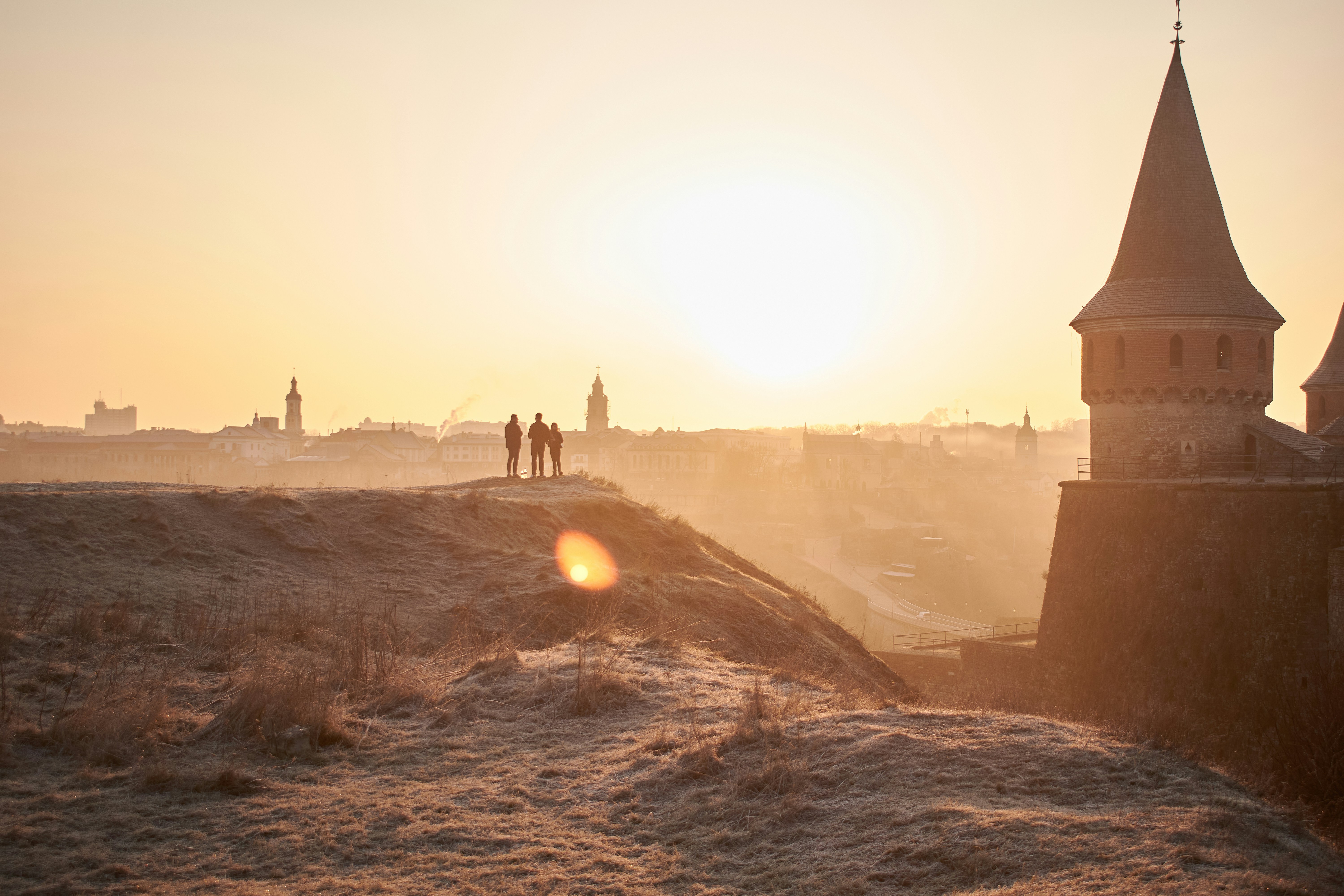 The sun is setting behind a castle like structure