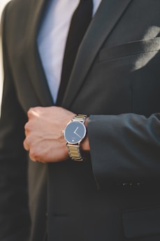 A close up of a person wearing a suit and a watch